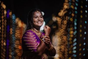 Charming bride in a vibrant saree amidst colorful bokeh lights, Chennai, India.